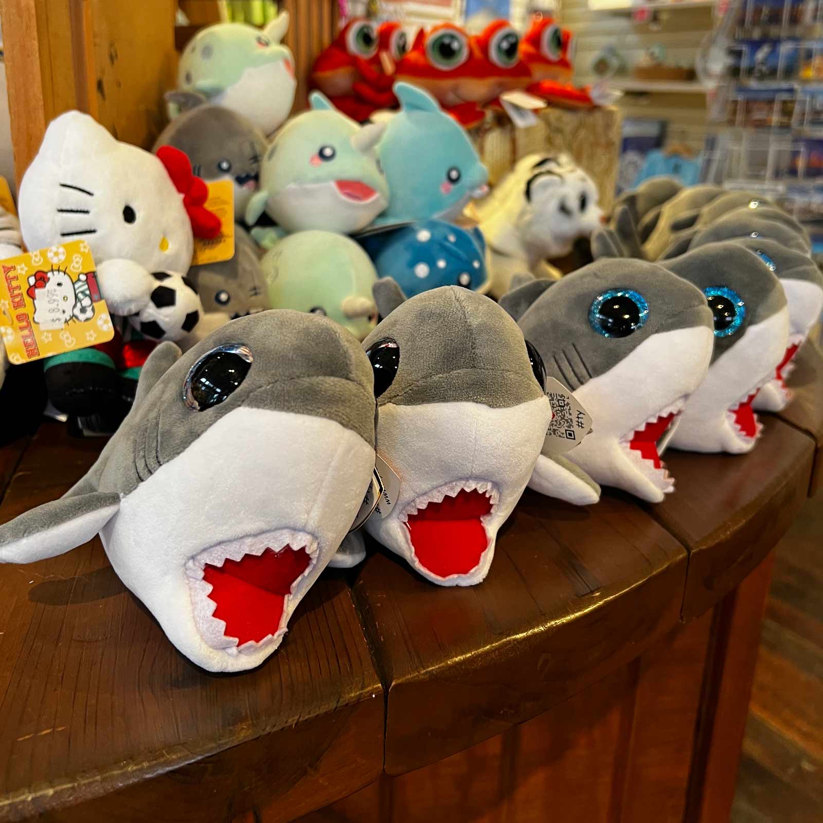 Cute little stuffed whales on a display table.