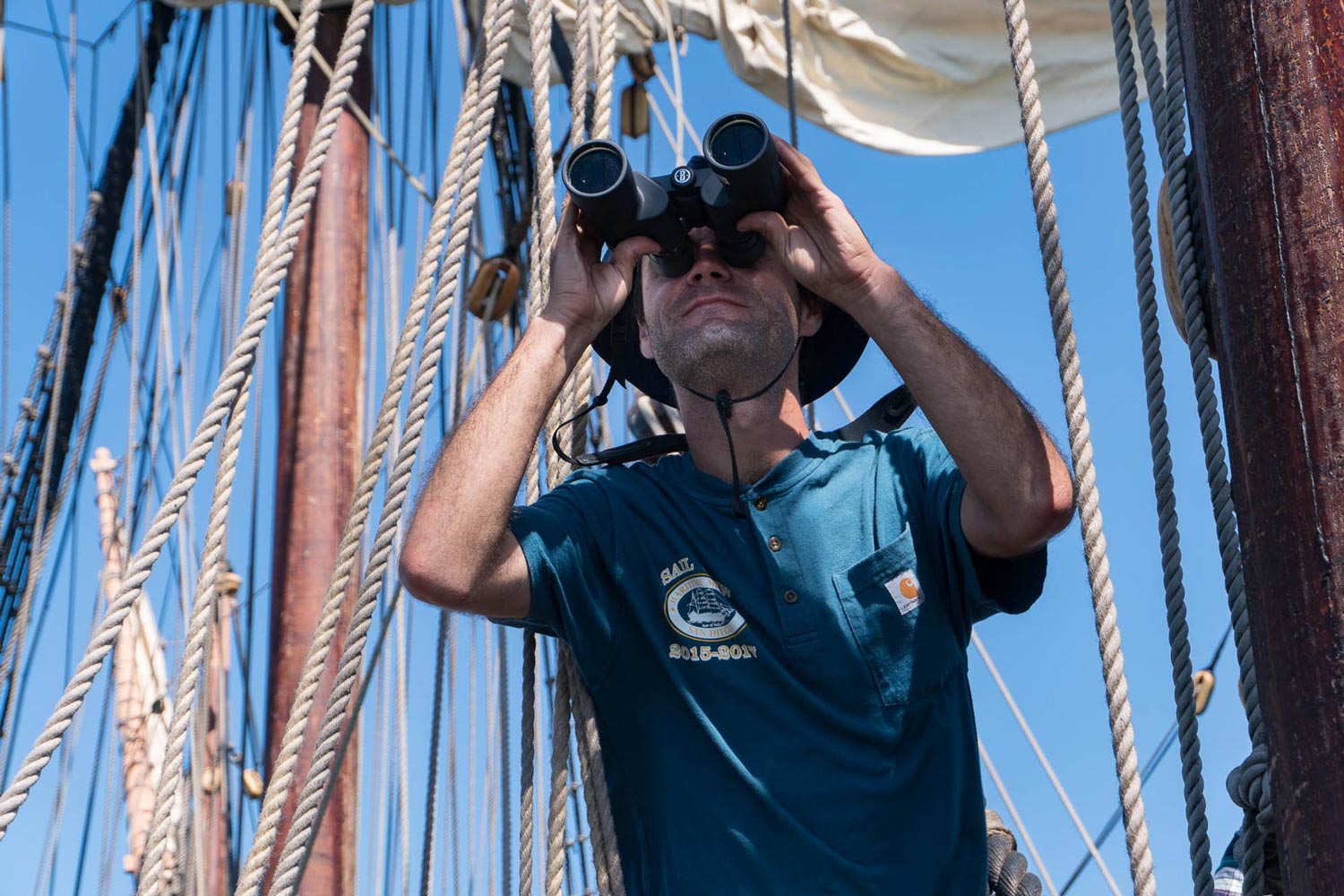 Viewing a distant object with binoculars while underway aboard San Salvador