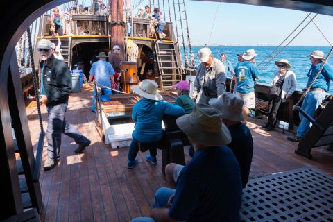 Guests milling about on the main deck while underway aboard San Salvador